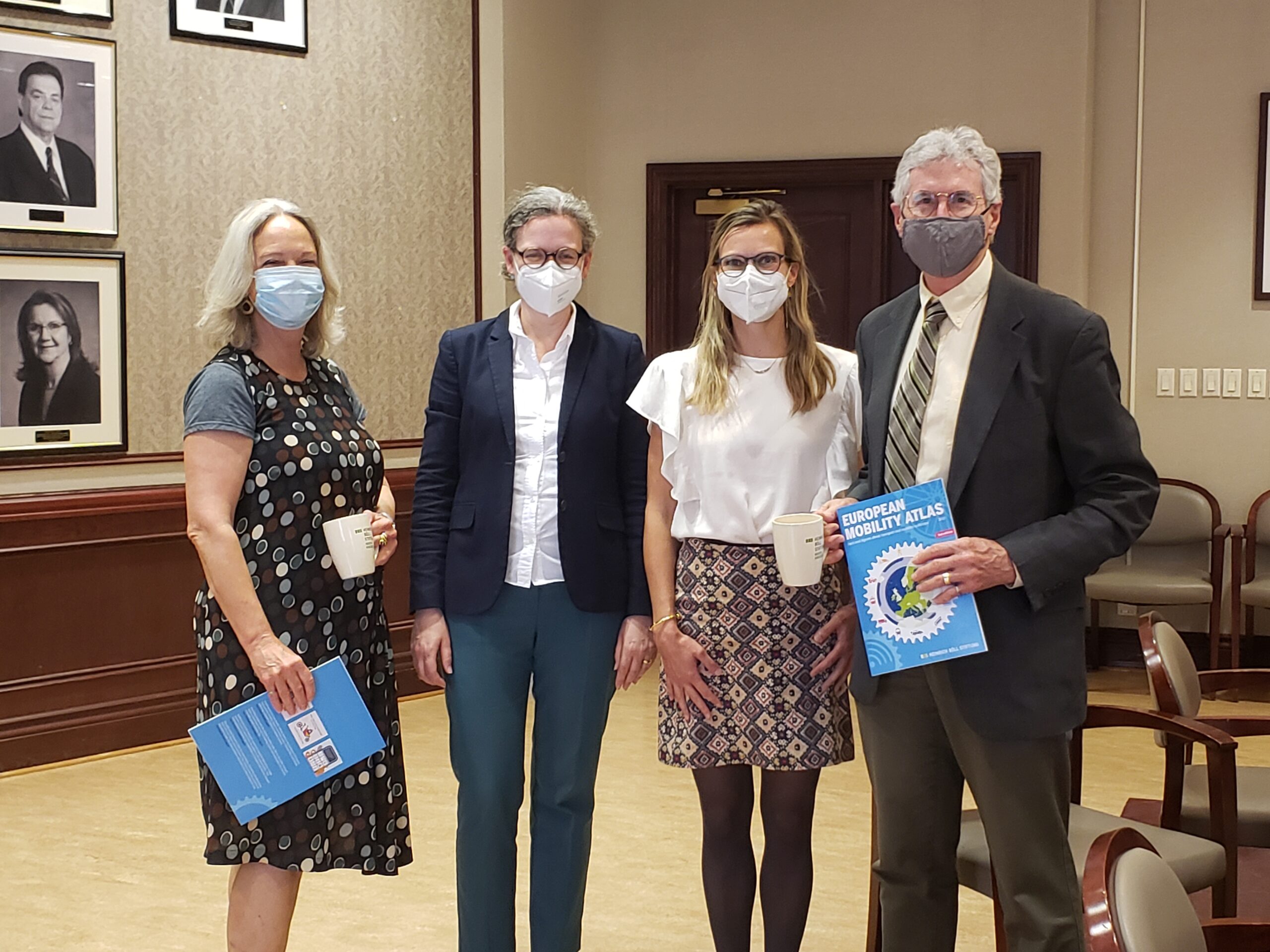 group of four pose for photograph wearing face masks