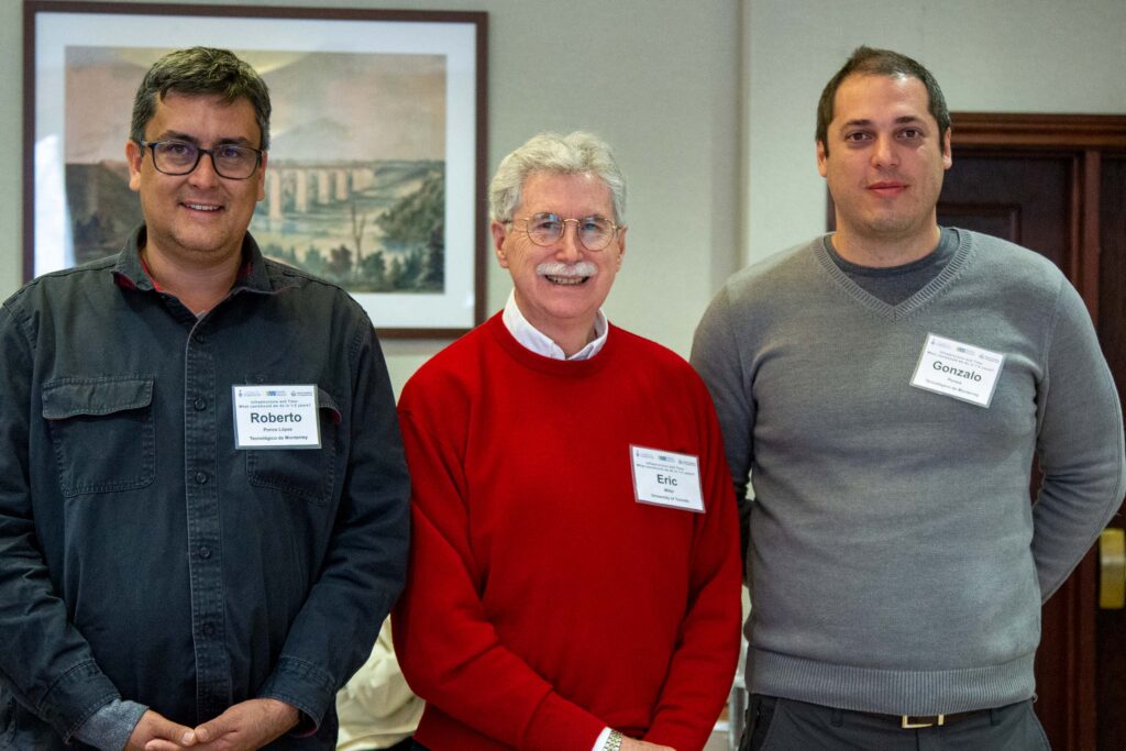 three standing men pose for photo